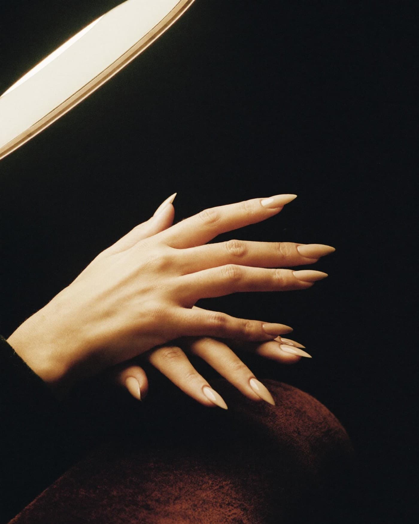 Manicure — close-up of hands under a salon lamp